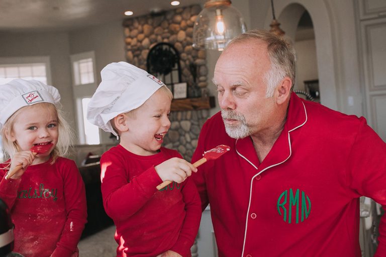 Grandfather baking with kids in red pajamas