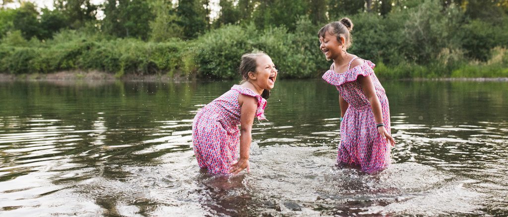 Two children laughing in a river