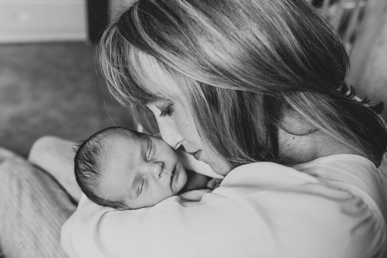 Mother lovingly cradles sleeping newborn baby