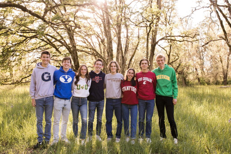 Group of friends wearing college sweatshirts outdoors.
