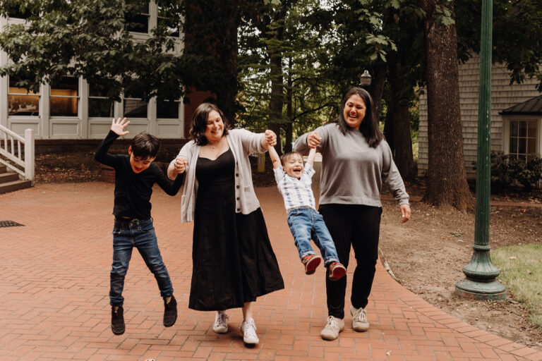 Happy family playing in park walkway.