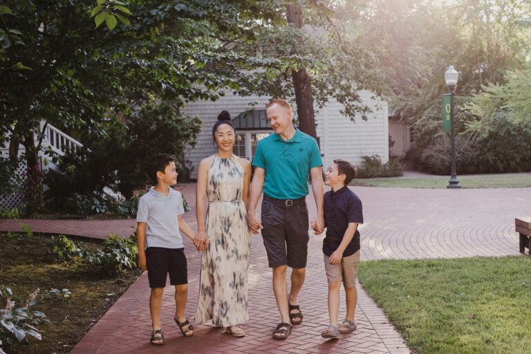 A lovely couple holds hands with their two young boys and strolls through the U of O campus.