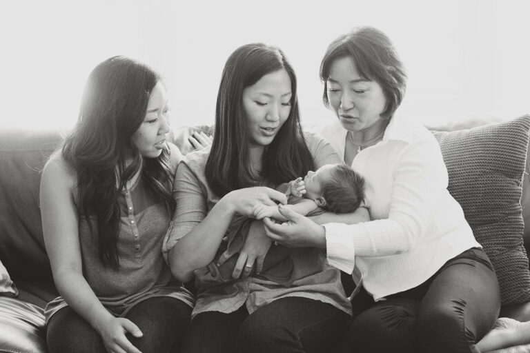 Family holding newborn on a couch.