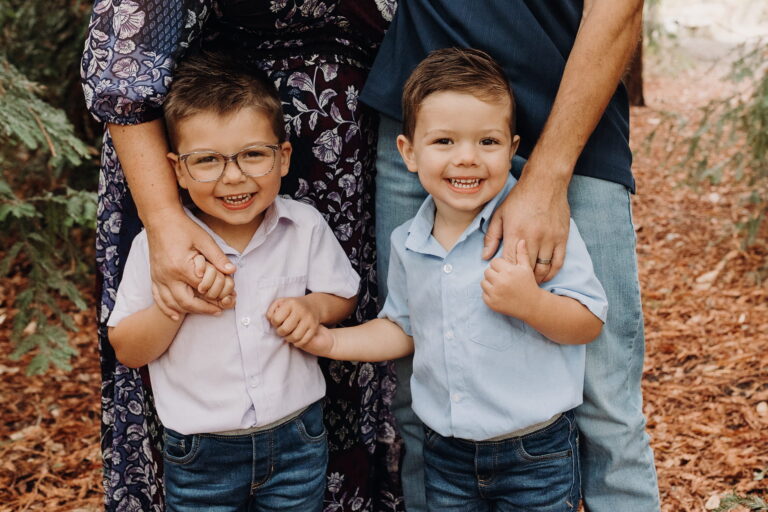Smiling young boys holding hands with adults.