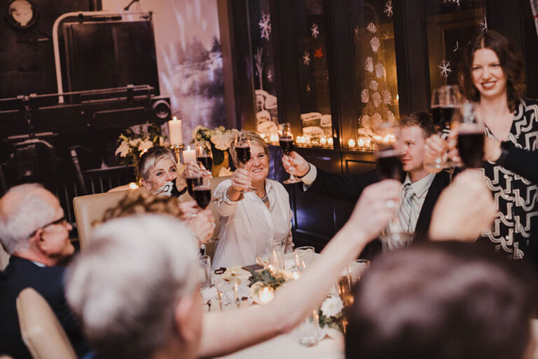 Group celebrating with wine at a festive dinner.